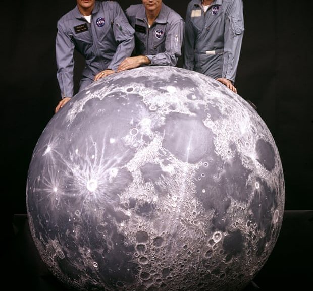 the apollo 11 crew with a model of the moon